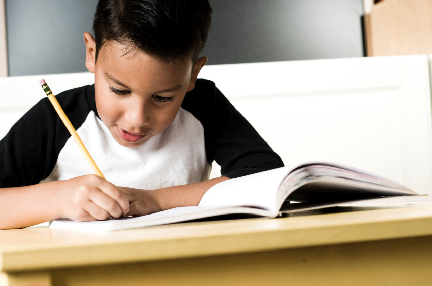 young student writing at desk