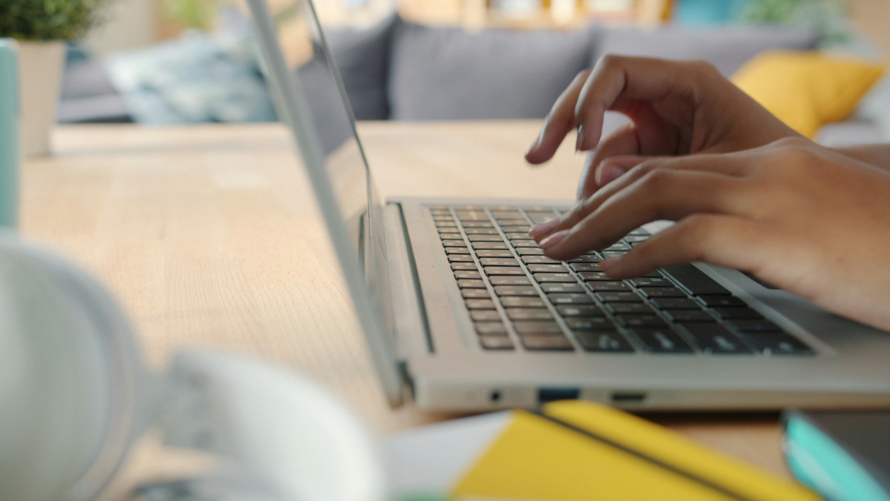 Girl Typing on Laptop with Blurred Background