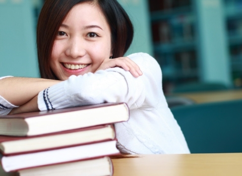 Smiling Student Leaning on Books